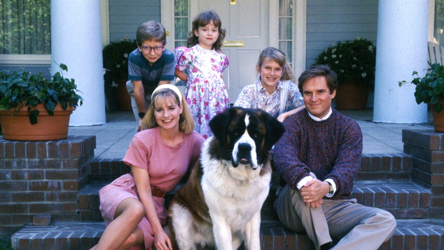 Família inteira posando para foto na entrada de casa com cão Beethoven ao centro