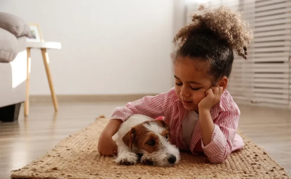 criança abraçada com cachorro