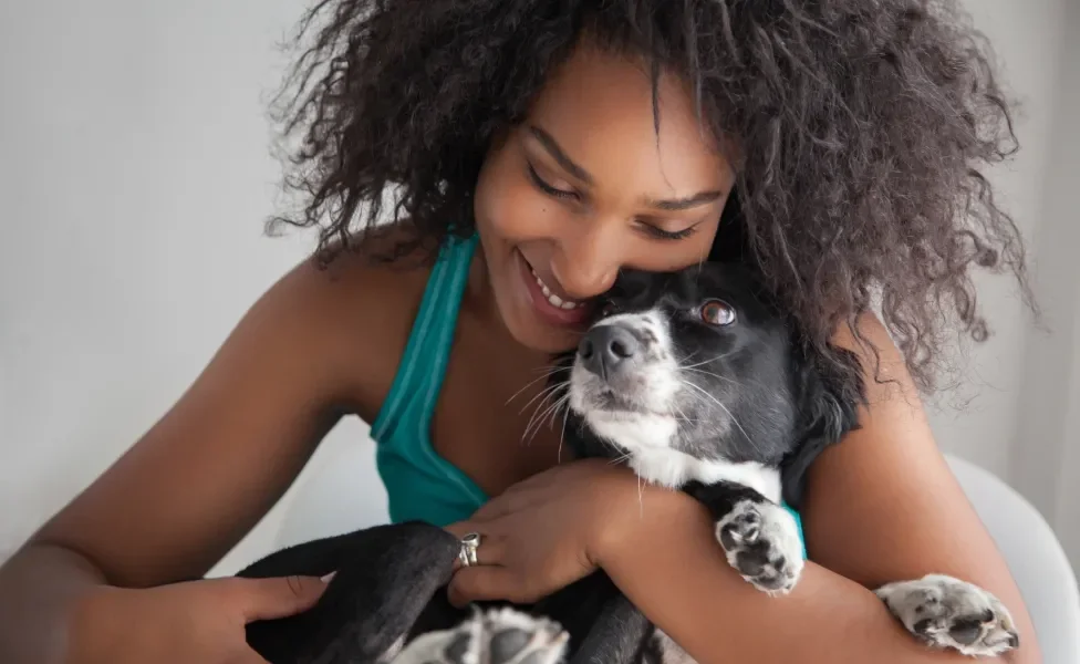 mulher abraçando cachorro