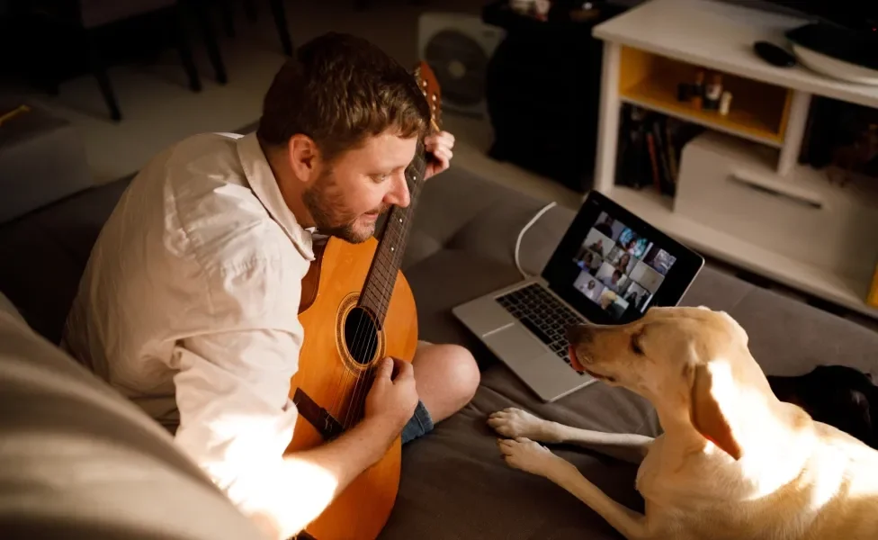 Cachorro ouvindo tutor tocando violão