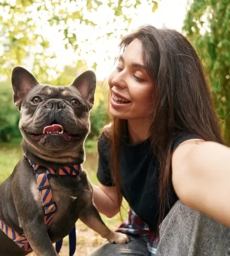 Mulher tirando selfie com cachorro da raça Bulldog em um parque