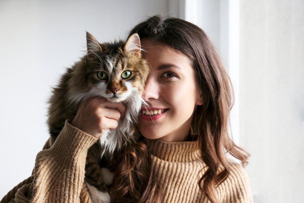 Mulher abraçando gato